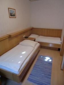 Zimmer mit 2 Betten und einem blauen Teppich in der Unterkunft Pension Daniela Steiner in Podersdorf am See