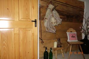 - une porte menant à une chambre avec des bouteilles de vin et une chaise dans l'établissement Bödmerhof, à Mittelberg