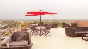 a balcony with chairs and tables and an umbrella at Hotel & Lounge Las Islas in San Juan Bautista Tuxtepec