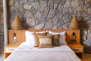 a bedroom with a bed and a stone wall at Birdcage 33 Hotel - Adult Only in Yalıkavak