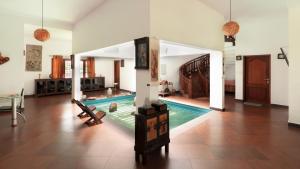 una sala de estar con piscina en una casa en SaffronStays WellBeingVilla, Wayanad, en Vythiri