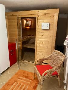 um quarto com um chuveiro, uma cadeira e uma porta de vidro em Austernfischer Haus em Pellworm