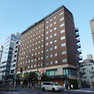 東京にあるホテルサンルート浅草の白車が目の前に停まった建物
