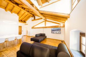 a living room filled with furniture and a large window at Alp Apartments - Xavier in Aosta