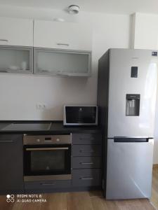 a kitchen with a white refrigerator and a microwave at Modern Apartman in Szeged