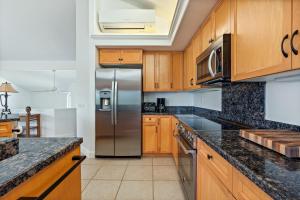 a kitchen with wooden cabinets and a stainless steel refrigerator at Villas of Kamalii 17 condo in Princeville