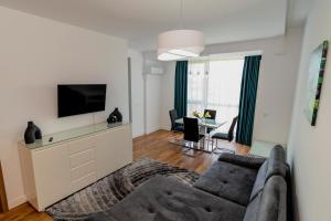 sala de estar con sofá y TV de pantalla plana en Summer Delight by Onix Blue Mamaia Nord en Mamaia-Sat