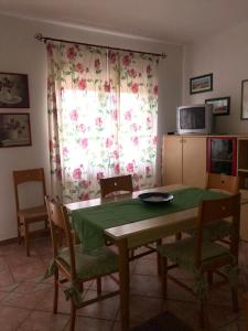 een eetkamer met een tafel en stoelen en een raam bij Residence Cala Chiesa in La Maddalena