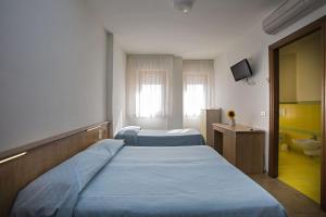 una camera ospedaliera con due letti e una televisione di Hotel Esperia ad Alba Adriatica