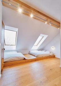 2 letti in una camera con pareti bianche e pavimenti in legno di Marel-Apartments dwupoziomowy 24 Willa Leśna Polanica Zdrój a Polanica-Zdrój