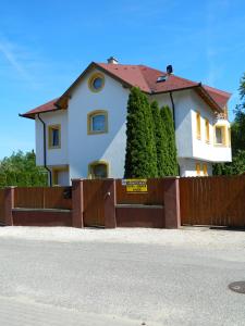 una casa detrás de una valla de madera con una puerta en Csernai Villa, en Balatonfüred