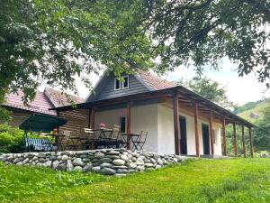 a house with a stone wall in front of it at Flore's Garden Glamping in Bran