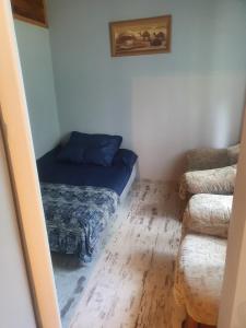Cette petite chambre comprend un lit et un canapé. dans l'établissement Dwa prywatne domki letniskowe nad Jeziorem Łukcze, à Krasne Kosów