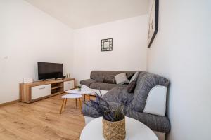 a living room with a couch and a tv at kuća za odmor ZARA in Stankovci