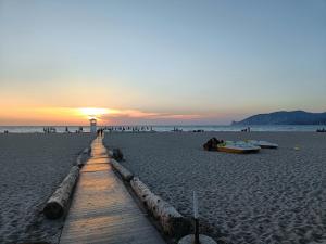 um caminho de madeira numa praia com o pôr-do-sol em Il Bronzetto em Gonnesa