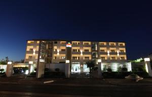 a large building with lights in front of it at night at Hotel Briganti in Qualiano