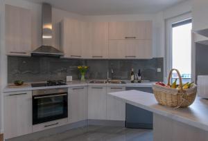 a kitchen with white cabinets and a basket of fruit on a counter at Empress apartment in Split