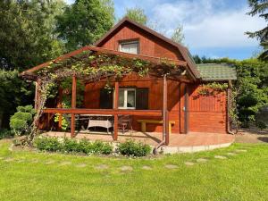 a small wooden cabin with a porch and a patio at Domek Sielanka Rybalnia in Szypliszki