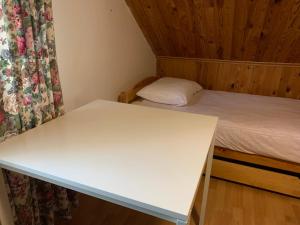 a white desk in a room with a bed at Domek Sielanka Rybalnia in Szypliszki