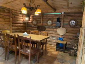 uma sala de jantar com uma mesa e cadeiras num camarote em Domek Sielanka Rybalnia em Szypliszki