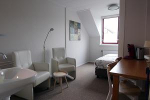 a bathroom with a sink and a bed in a room at Texelstrand in Den Hoorn