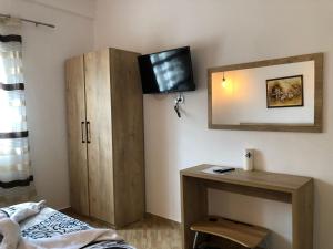 1 dormitorio con armario y TV en la pared en Hotel Apostoli en Përmet