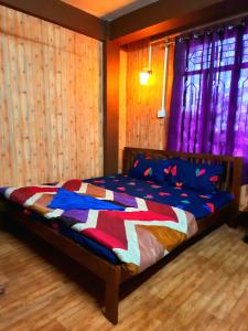 Un dormitorio con una cama con una colcha colorida. en The Sangam Homestay en Kalimpong