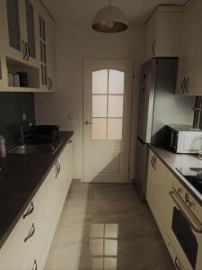 - une cuisine avec une porte blanche et un évier dans l'établissement 2H Apartment, à Sarajevo