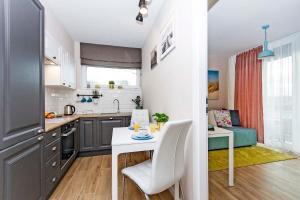 a kitchen with a table and a dining room at Apartament Sun Mare in Gdańsk