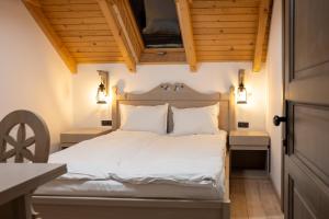 a bedroom with a white bed with wooden ceilings at Pension Mama Cozonacilor in Bran
