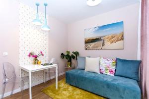 a living room with a blue couch and a table at Apartament Sun Mare in Gdańsk