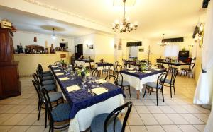 restauracja ze stołami i krzesłami z niebiesko-białymi obrusami w obiekcie Valle D'Agrò w mieście Savoca