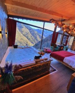 a bedroom with a large tub with a mountain view at Seyr-i Cennet Dag Evleri in Çamlıhemşin