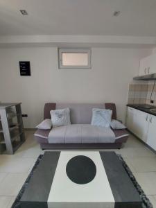 ein Wohnzimmer mit einem Sofa und einem Tisch in der Unterkunft Studio apartment Portofino in Dubrovnik