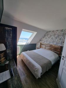 a bedroom with a large bed and a window at Hôtel Vauban in Le Palais