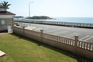 a road next to the ocean with a fence at Desconectaengalicia La Lanzada, a pie de playa in A Lanzada