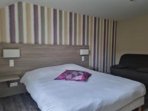 a bed in a hotel room with a pillow on it at Hôtel Vauban in Le Palais