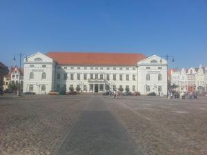 a large white building with a red roof at Pension Am Wassertor in Wismar
