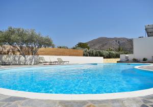 a large swimming pool with blue water at Rousolakos Apartments in Palekastron