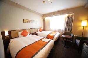 a hotel room with two beds and a window at Hotel Sunroute Asakusa in Tokyo