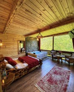 a bedroom with a large bed in a wooden room at Seyr-i Cennet Dag Evleri in Çamlıhemşin