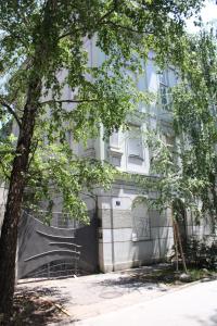 een wit gebouw met een garage ervoor bij Garden Center Apartment in Novi Sad