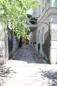 an alley way in a building with a tree at Garden Center Apartment in Novi Sad