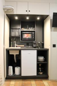a kitchen with a sink and a microwave at Garden Center Apartment in Novi Sad