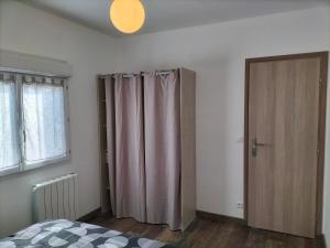 a bedroom with a bed and a closet with curtains at Maison plain pied 4 personnes parking gratuit in Vendeville