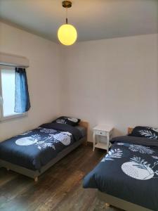 une chambre avec deux lits et une fenêtre dans l'établissement Maison plain pied 4 personnes parking gratuit, à Vendeville