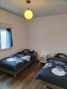 a bedroom with two beds and a window at Maison plain pied 4 personnes parking gratuit in Vendeville