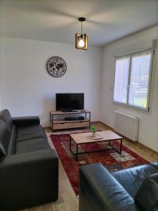 uma sala de estar com um sofá e uma mesa de centro em Maison plain pied 4 personnes parking gratuit em Vendeville