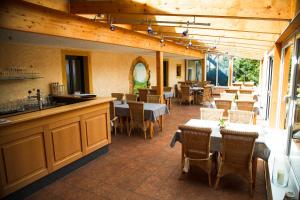 ein Restaurant mit Tischen und Stühlen und einer Theke in der Unterkunft Hotel Fronhof Mettendorf in Mettendorf