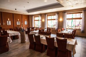 a dining room with tables and chairs and windows at Hotel Fronhof Mettendorf in Mettendorf +25 photos